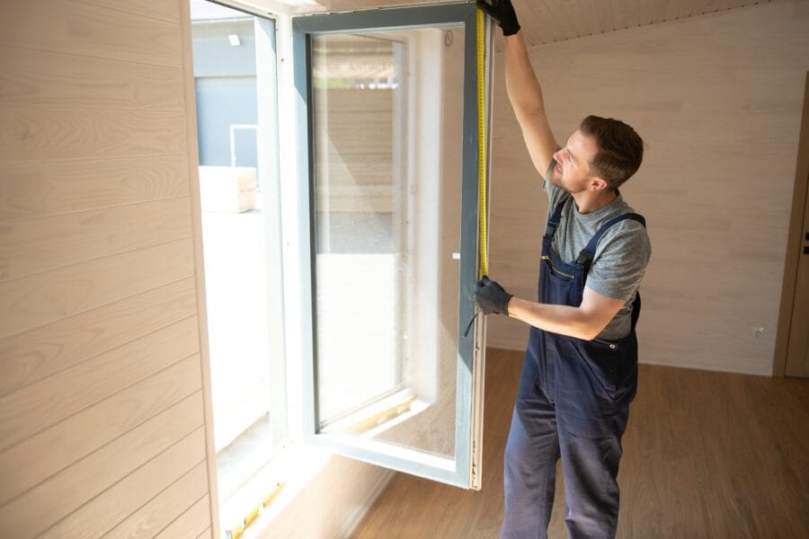 Arbeiter installiert Fenster in einem Haus