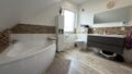 Familienbad mit Eckbadewanne, Dusche, Doppelwaschtisch und separatem WC