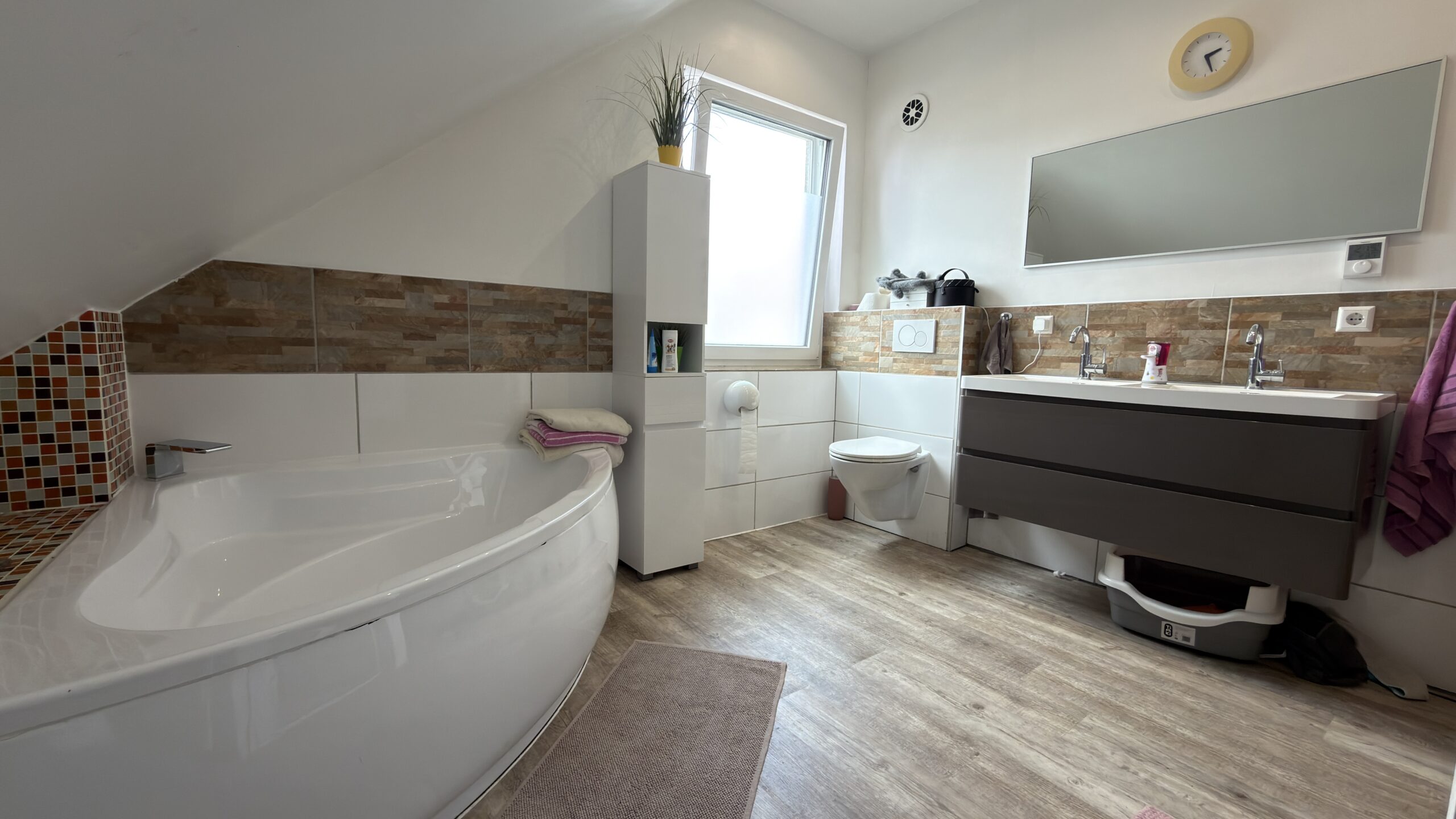 Familienbad mit Eckbadewanne, Dusche, Doppelwaschtisch und separatem WC
